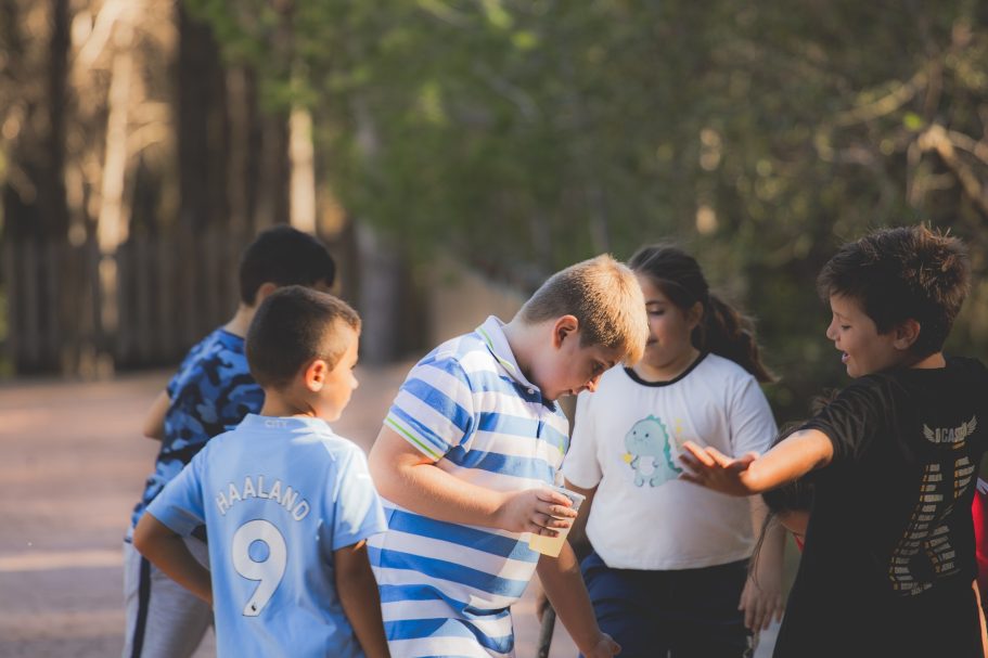 Grupo de niños jugando al aire libre en un camino natural.