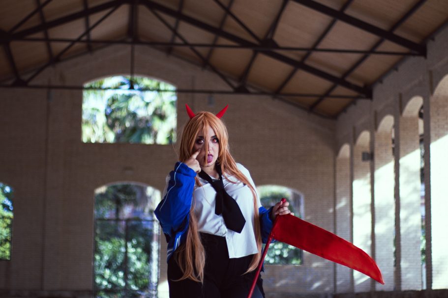 Personaje con cuernos y capa, en un espacio arquitectónico con luz natural.