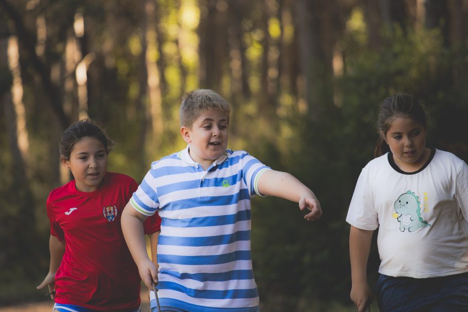 Tres niños caminando juntos por un sendero en un entorno natural.