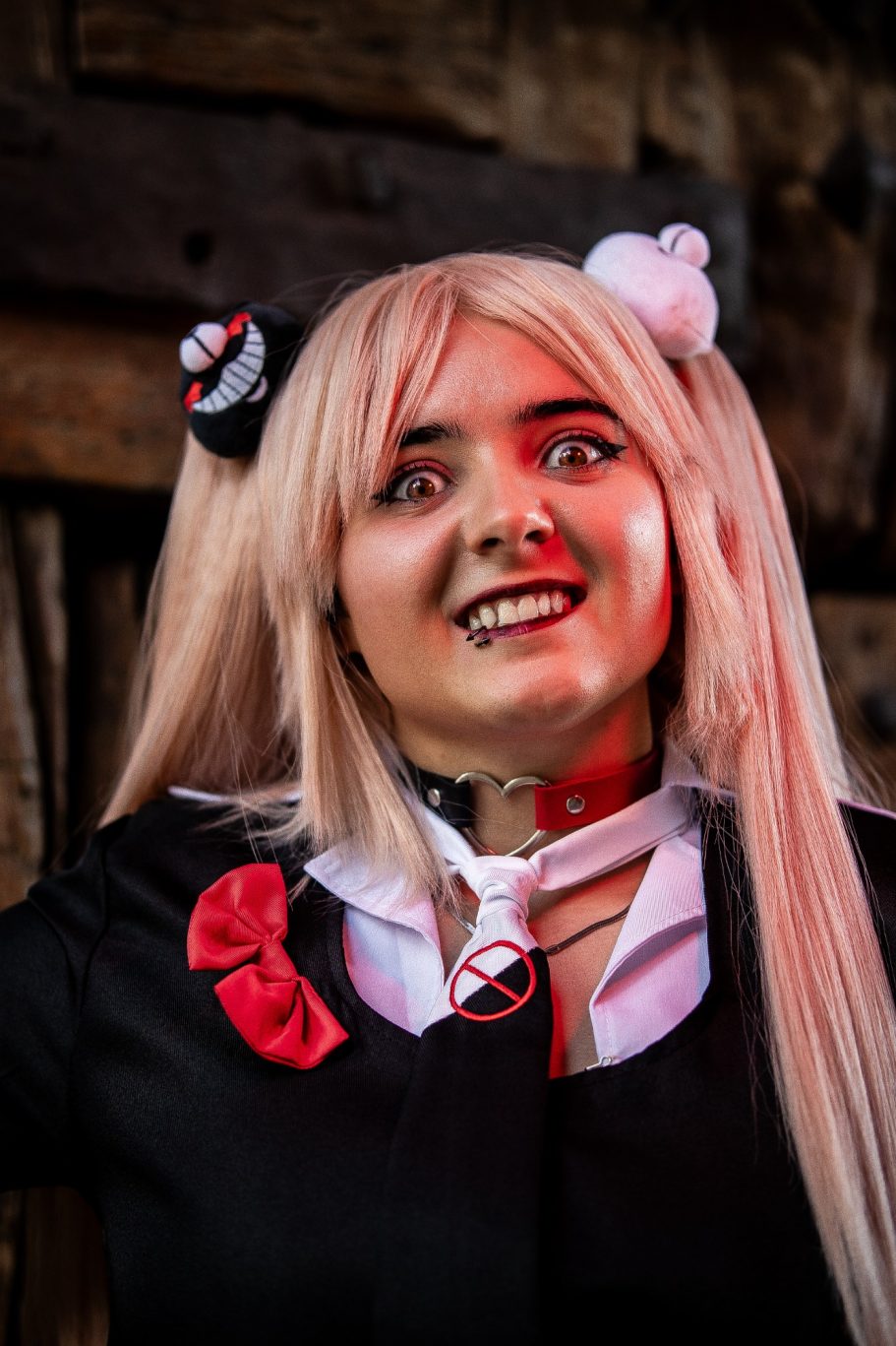 Chica con pelo largo y rubio, vestida de cosplay con expresión divertida y accesorios.