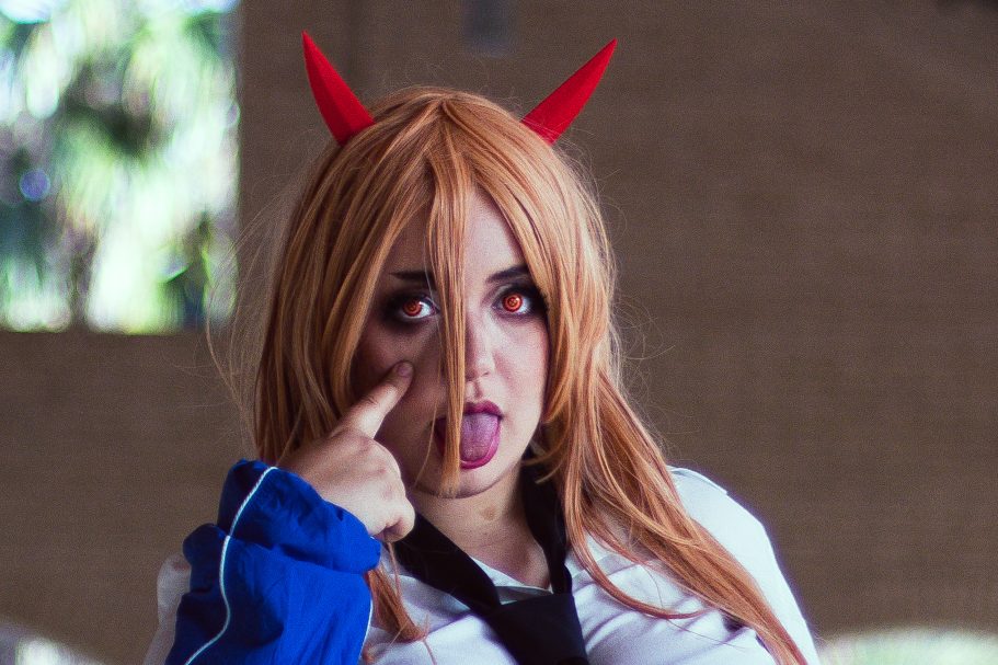 Mujer con peluca rubia y cuernos rojos, haciendo una expresión divertida.