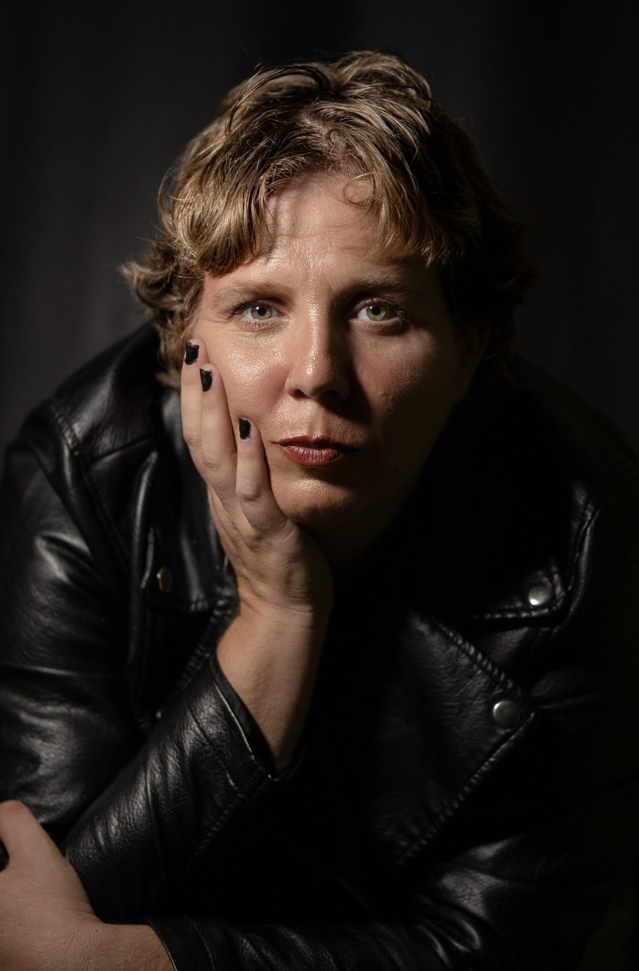 Retrato de una persona con cabello corto, vestido con chaqueta de cuero, mirando hacia adelante.